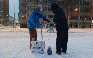 straat consulaat medewerker helpt dakloze tijdens winterkou